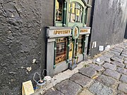 Miniature model of a pharmacy façade with chairs outside