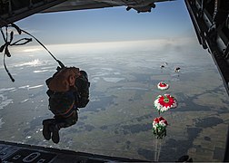 Bangladesh Air Force paratroopers descend from a C-130 aircraft