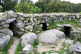 muraille circulaire vue de l’intérieur et en appareil rustique irrégulier, avec 3 entrées basses de chambres souterraines