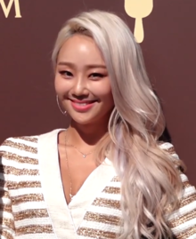Hyolyn smiles and looks right