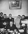 Signature du pacte germano-soviétique par Viatcheslav Molotov. Ribbentrop et Staline sont en arrière-plan.