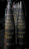 M107 artillery shells. All are labelled to indicate a filling of "Comp B" (mixture of TNT and RDX) and have fuzes fitted