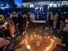 Students at Southwest Jiaotong University, Chengdu, holding a candlelight vigil for victims of the fire. The candles are arranged in a heart shape. The faces of students are blurred to protect anonymity.