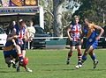 British Bulldog manages to get a kick away despite being tackled by a Nauruan opponent during the 2008 Australian Football International Cup.