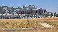 Outside view of Rockbank Station looking at carpark and station concourse in the distance, February 2024