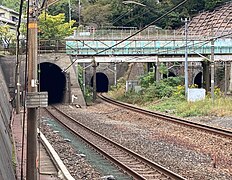 東山隧道下り外側線東口坑口（中央左）と北花山第2跨線橋（水色柵の鋼橋）