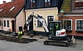 A smaller excavator is digging for the laying of a broadband cable in central Ystad in 2021