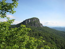 A huge rock on top of a mountain with a flat top