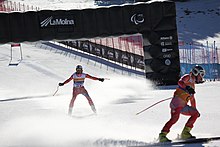 Pair of skiers crossing finish liner