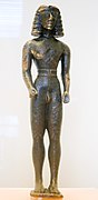 Statuette de couros dédalique. Bronze, H. 19,6 cm. Crête. 625-600. Musée archéologique de Delphes[182]