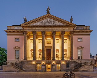 Ópera Estatal de Berlim, reaberto em 7 de dezembro de 2017 após vários anos de renovação. O edifício é uma casa de ópera na avenida Unter den Linden 7, no bairro Mitte de Berlim. Construído em 1741−1743 por ordem de Frederico, o Grande, segundo planos de Georg von Knobelsdorff no estilo rococó fridericiano, foi reconstruído por Richard Paulick de 1951–1955 após a destruição durante a Segunda Guerra Mundial. É a mais antiga casa de ópera de Berlim e o “primeiro teatro significativo a ser construído como uma estrutura monumental e independente em uma cidade”. (definição 4 352 × 3 482)