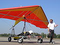 The kite hang glider is readying for being a kite in two ways; during kiting tug by the ultralight powered hang glider trike the system is a long-line kite being towed; then upon release from tug, the kite hang glider is a short-kite-lined free-flight kite with a dominant aim of gliding.