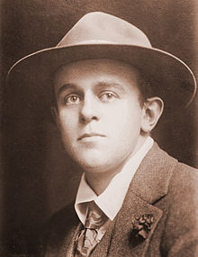 Mid-length photograph of a man of about 25 in a jacket, tie, and fedora.