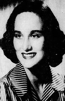 Black and white photograph of a short haired woman looking to her right wearing a striped blouse