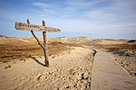 Sandy dune, a wooden trail and a wooden sign board