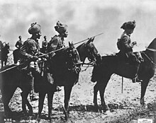 Three Indian horsemen in the foreground, the man on the left carries a lance a sergeant is in the middle and an officer on the right. In the background can be seen three further cavalrymen