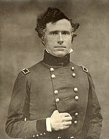 Photographie d'un homme en uniforme aux cheveux bouclés