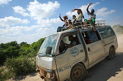 Passagers d'un taxi collectif saluant le passage d'un convoi de l'Amisom en 2010.