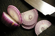 Cut onions emit a chemical compound which cause the lacrimal glands in the eyes to become irritated, releasing tears.