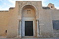 Porche de la façade orientale (quatrième à partir de l'extrémité sud), ouvert par un arc en plein cintre outrepassé.