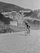 Photographie en noir et blanc d'un cycliste en course.