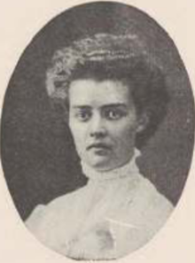 A young white woman with wavy hair in a bouffant style; she is wearing a high-collared white shirtwaist