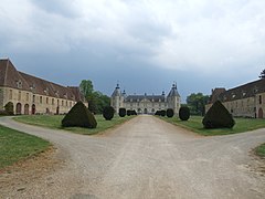 L’allée bordée de buis encadrée par les communs