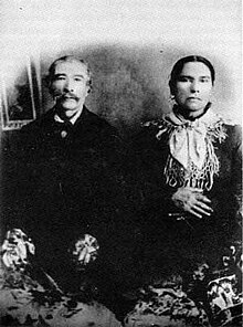 A black and white portrait photograph of Joseph St. Germain and Marie Anne Plamondon seated next to each other, in late middle age