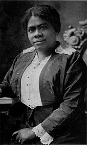 Portrait of a black woman in a shirtwaist dress and dark colored jacket with lace trim