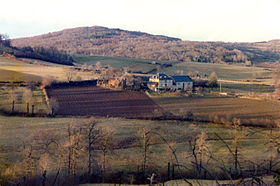 Au premier plan, les flancs du puy de Montiroir avec le hameau de Montiroir.