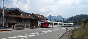 Red and white electric train at a station