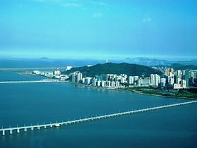 Vue de la côte nord de Taipa depuis la tour Macao sur la péninsule de Macao avec deux des trois chaussées reliant ces deux quartiers au premier plan ainsi que la piste de l'aéroport international de Macao au dernier plan.