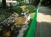 新宿御苑北縁の“散歩道”[15]。 直下にあるトンネルに湧く水を汲み上げて利用。トンネルに並行して玉川上水の遺構が埋まっている。 （新宿区内藤町・新宿1丁目、北緯35度41分15.97秒 東経139度42分42.52秒﻿ / ﻿北緯35.6877694度 東経139.7118111度﻿ / 35.6877694; 139.7118111﻿ (新宿御苑北縁の散歩道)）