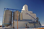 Grain elevator on snow, against a blue sky