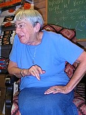 Le Guin seated in a bookstore
