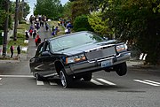 A 1994 Cadillac Fleetwood lowrider 3-wheeling during the Fiestas Patrias Parade, South Park, Seattle, Washington