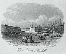 Lithograph of a dock area with sandstone buildings, tall ship masts, a steam train and people