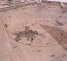 Wreckage in outline of burned-out aircraft; only the tail assembly is intact