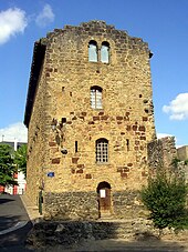 La façade d'une maison en pierres avec une porte et quatre fenêtres