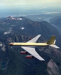 Le Dash 80 passe au-dessus de la péninsule Olympique, dans l'État de Washington ; le lac Cushman, le Puget Sound et le mont Rainier sont visibles en arrière-plan.