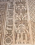 Arabesque and pine cone motifs along with Kufic inscriptions around the Ben Youssef Madrasa's mihrab, in Marrakesh (16th century)