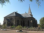 Imposing cruciform stone building with pointed Gothic windows and doorways. Porches on three sides. Corrugated iron roof. Sturdy tower with spire and weather-cock. Ornamental diagonal butresses at corners. This neo-Gothic church, the cornerstone of which was laid on 12 November 1912, was erected by the builder Van der Hoven in the years 1912-1913 from locally procured stone and other material. The church was officially consecrated on 31 August 1913 by the R Type of site: Church Current use: Church : Dutch Reformed. This neo-Gothic church, the cornerstone of which was laid on 12 November 1912, was erected by the builder Van Der Hoven in the years 1912-1913 from locally procured stone and other material. The church was officially consecrated on 31 August 1913 by the R