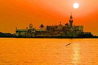 Photo: The Haji Ali Dargah, built in 1431, in the Mahim Bay can be reached from Mahalaxmi by a narrow causeway, and that only at high tide, when it is above the sea. A handsome example of Indian Islamic architecture, associated with legends about doomed lovers, the dargah contains the tomb of Saint Haji Ali. It sits 500 yards off the coast in the waters of Mahim Bay, near the neighborhood of Worli. It is connected with the Mahalaxmi Temple via a small path that goes into the sea, only accessible during low tide.