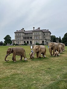 A group of elephants sculpted from Lantana camara vines on The Breakers' lawn with the mansion in back