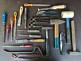 A collection of hand tools including hammers, pliers, chisels, files, screwdrivers, and crowbar