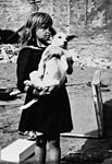 ילדה אוחזת בכלבה רואה את ההרס שנגרם במהלך התקפות אוויריות גרמניות בקרבות המצור על ורשה.