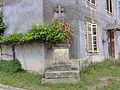 Croix de chemin contre une maison.