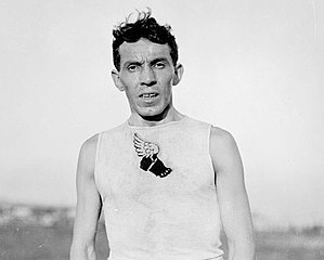 Un homme en maillot blanc et un logo noir.