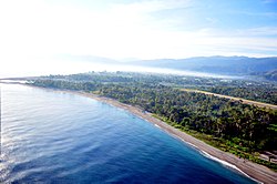 Vorn der Praia Lusitana und der Flughafen. Hinter dem Rio Comoro erkennt man die Bucht von Dili. Die Häuser von Marinir verschwinden hinter den Bäumen.