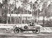 Photo d'un véhicule roulant à grande vitesse le long d'une route boisée.